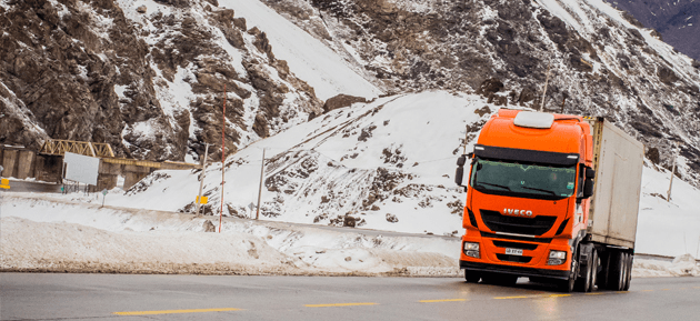 Camión de carga atravesando un paso cordillerano con nieve